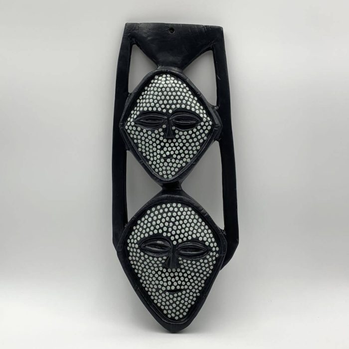Vooraanzicht van Afrikaans geïnspireerd houten wandmasker – dubbele gezichten in zwart met witte stippen, handgemaakt en symmetrisch vormgegeven