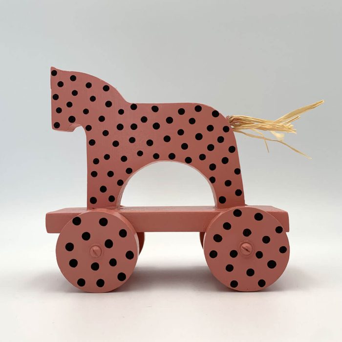 Ambachtelijk houten paard – roze met zwarte stippen – decorstuk op wieltjes met speels karakter