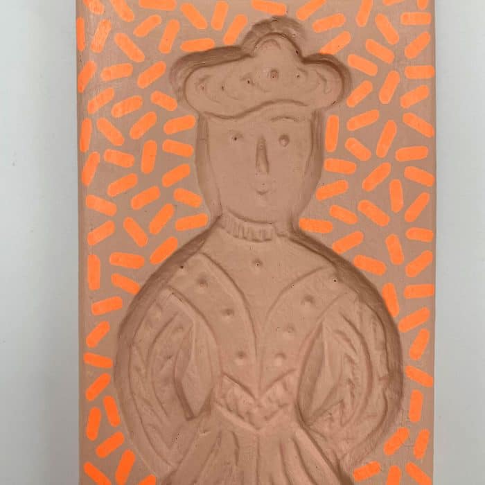 Vooraanzicht van handgeschilderde houten wanddecoratie – zachtroze achtergrond met fluorescerend oranje patronen en twee figuren in reliëf